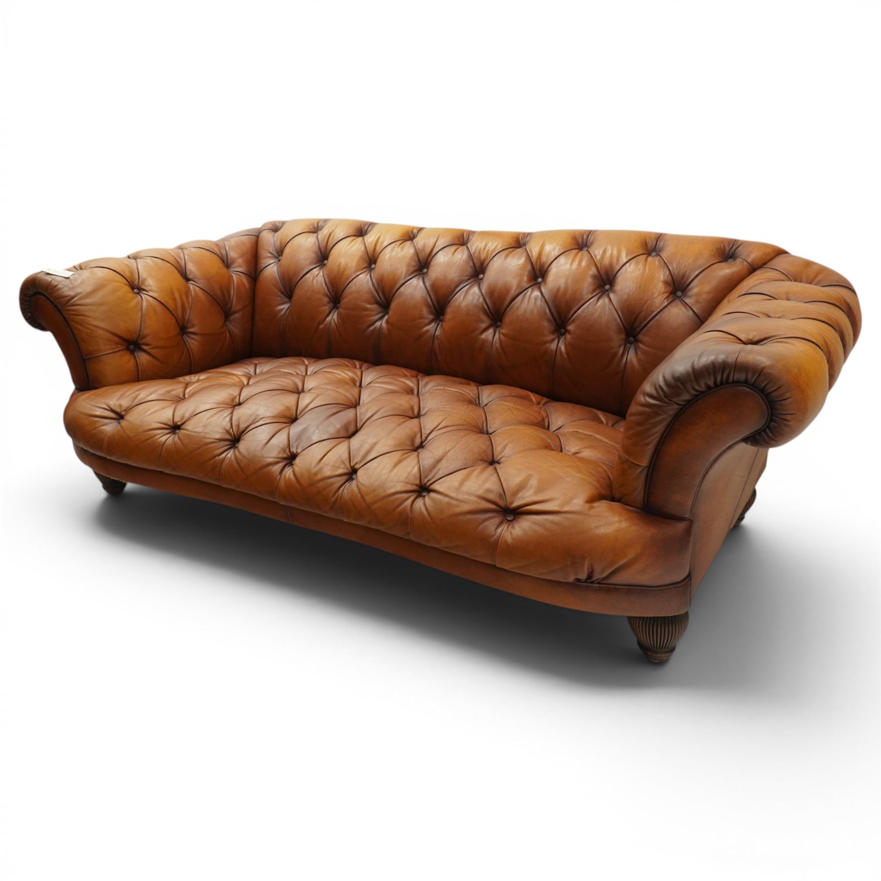 Tetrad - 'Oskar' grande three-seat sofa, Chesterfield shape with rolled arms over serpentine back and front, upholstered in fully buttoned tan leather, raised on reed-moulded feet of globular form
