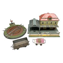 '0' gauge - Bing tin-plate two-storey double sided station with open walk-through to one end, rail side canopy, hinged doors and removable roof giving access to clock illumination L35cm; Bing hand-cranked turntable and open wagon; Marklin tin-plate level crossing barrier and Newspaper vendor's tin-plate four-wheel hand cart (5)