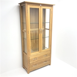 Light oak display cabinet, projecting cornice, two doors enclosing glazed shelves above two drawers, stile supports, W88cm, H180cm, D39cm