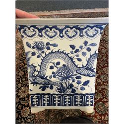 Chinese blue and white planter and stand, each of square slightly tapering and flared form, the planter decorated with two dragons and blossoming peonies, between stylised borders, the stand decorated with flower heads and vines, planter H30cm W29cm, stand H7cm D28.5cm