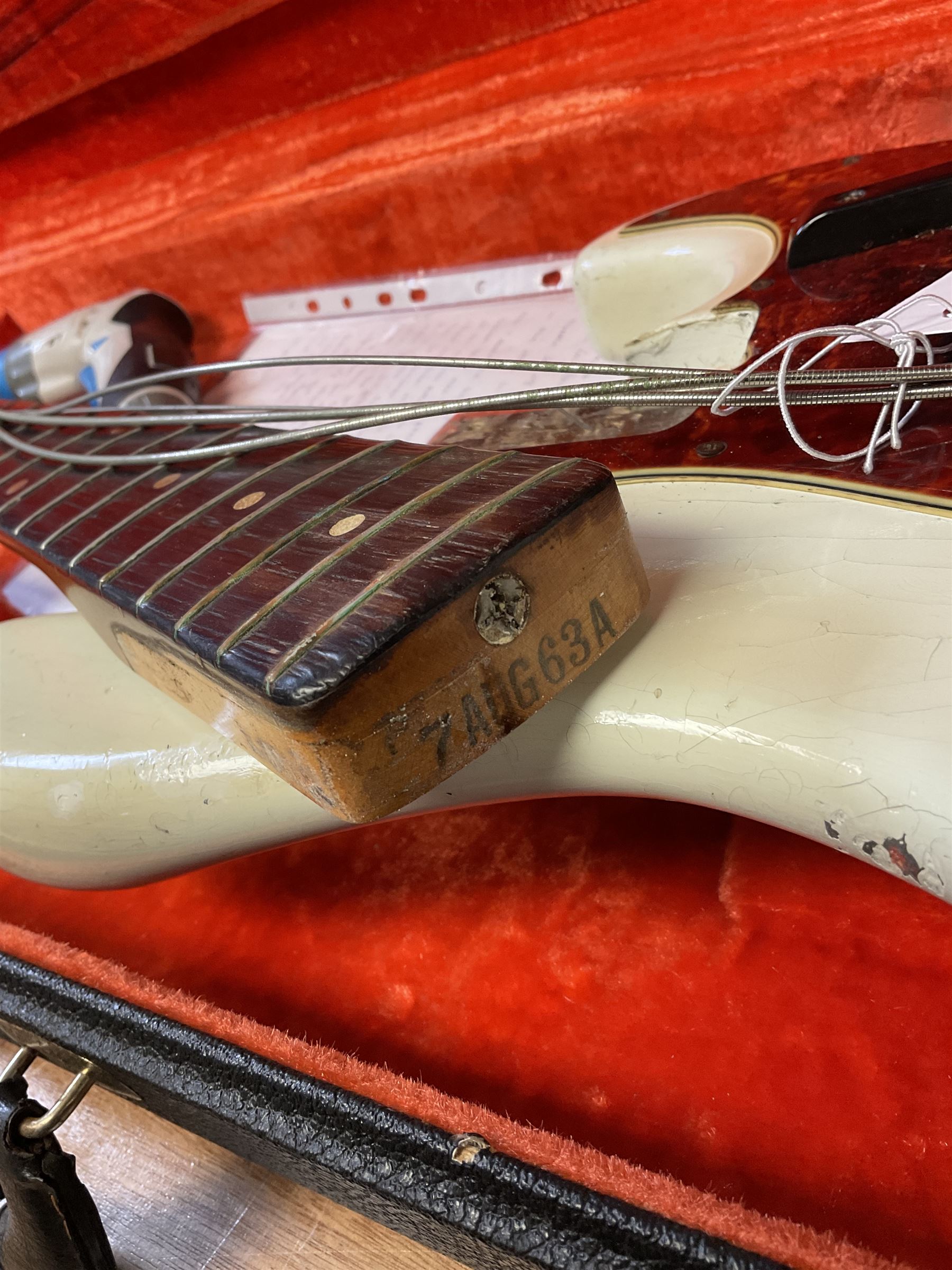 1963 Fender Jazz three-knob bass guitar; impressed with date code 7AUG63A on end of neck and serial no.L08587 on back plate; all original but re-finished in white in the 1970s; sold with photographs of the instrument in the 1960s with original finish and in the 1970s re-finished; L117.5cm; in original hard carrying case; Provenance: the professional guitar of Howard Livett from new to his death in 2005. Howard played in The Humperdincks, the backing group for Englebert Humperdinck, also played in the backing group for Max Bygraves and in the band Hedgehoppers Anonymous. The guitar is also sold with a manuscript letter of provenance from Howard's wife.