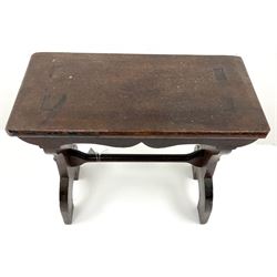 20th century hardwood vernacular joint stool, rectangular top with shaped apron, on two splayed end supports joined by pegged stretcher