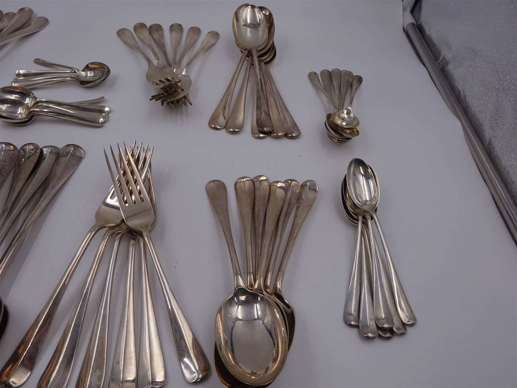 1930s matched set of silver Hanoverian pattern flatware, each with rattail bowls, to include four table spoons, twelve dessert spoons, twelve table forks, twelve dessert forks, twelve teaspoons and twelve coffee spoons, all hallmarked with various makers and dates 
