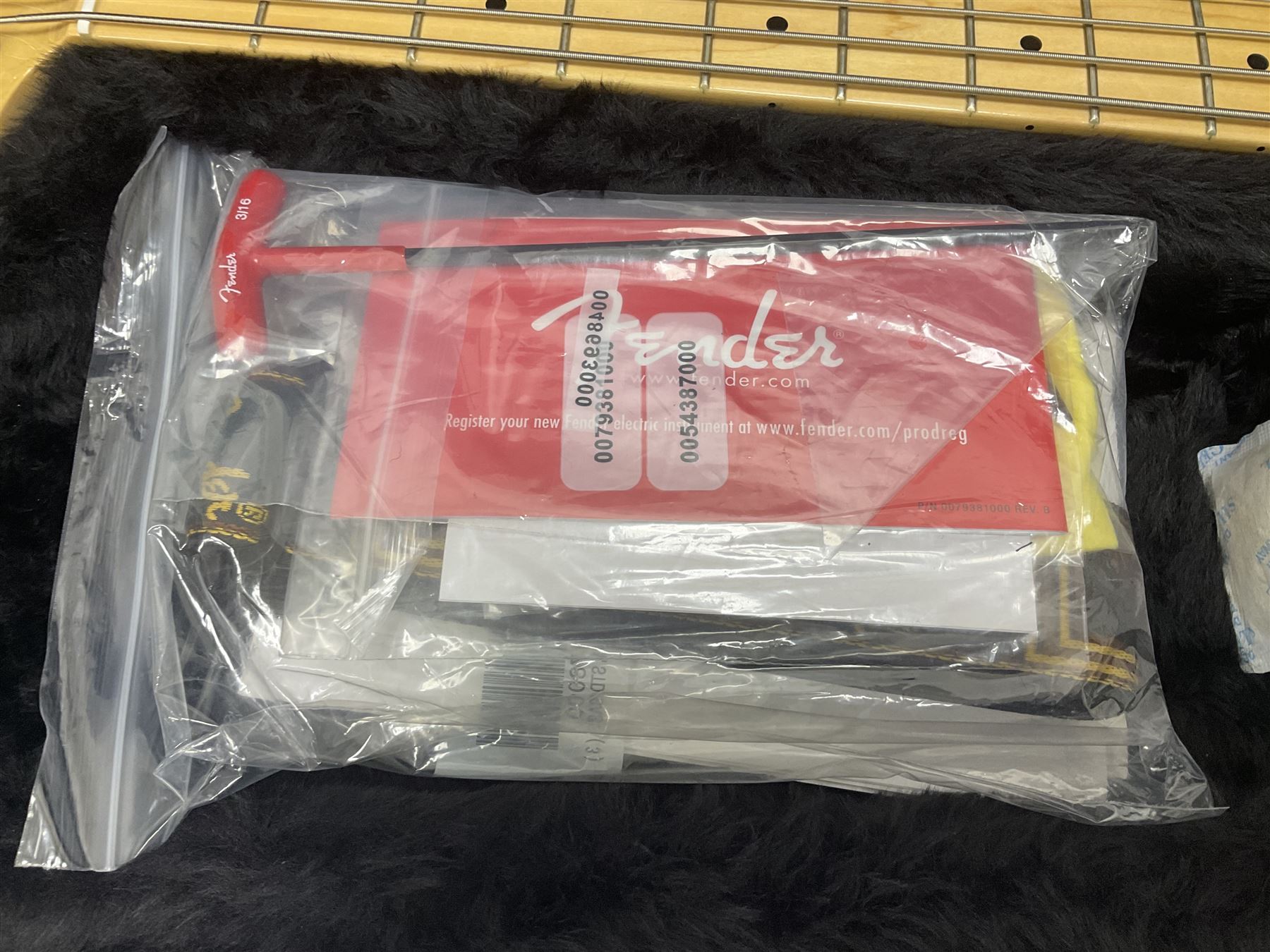 Fender Precision Bass guitar, in Olympic White finish with tortoiseshell effect scratchboard, serial no US15103092, in black Fender hard case with Fender strap and warranty card, guitar L116cm