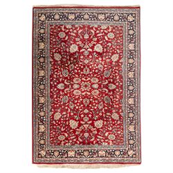 Persian crimson ground rug, interlacing floral stems linking ivory palmettes, rosettes and...