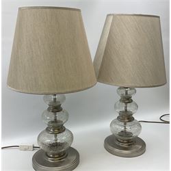 A pair of crackle glass table lamps each of three spheres, on circular metal bases, with silver lampshades, H61cm with shades.  