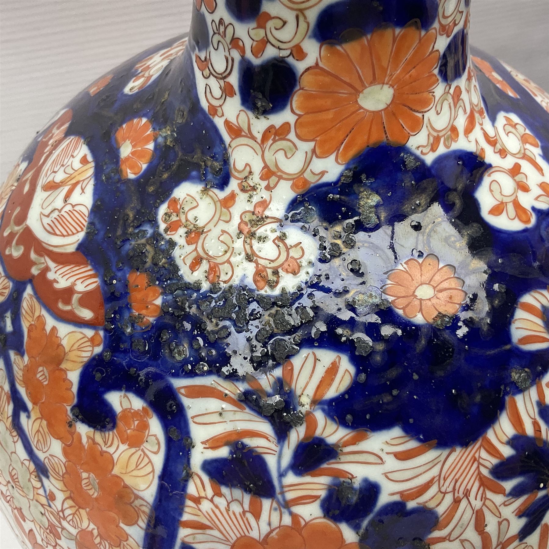 Pair of large 19th century Japanese Imari porcelain bottle vases, painted with shaped reserves of peonies, chrysanthemums and prunus blossom, each H46cm