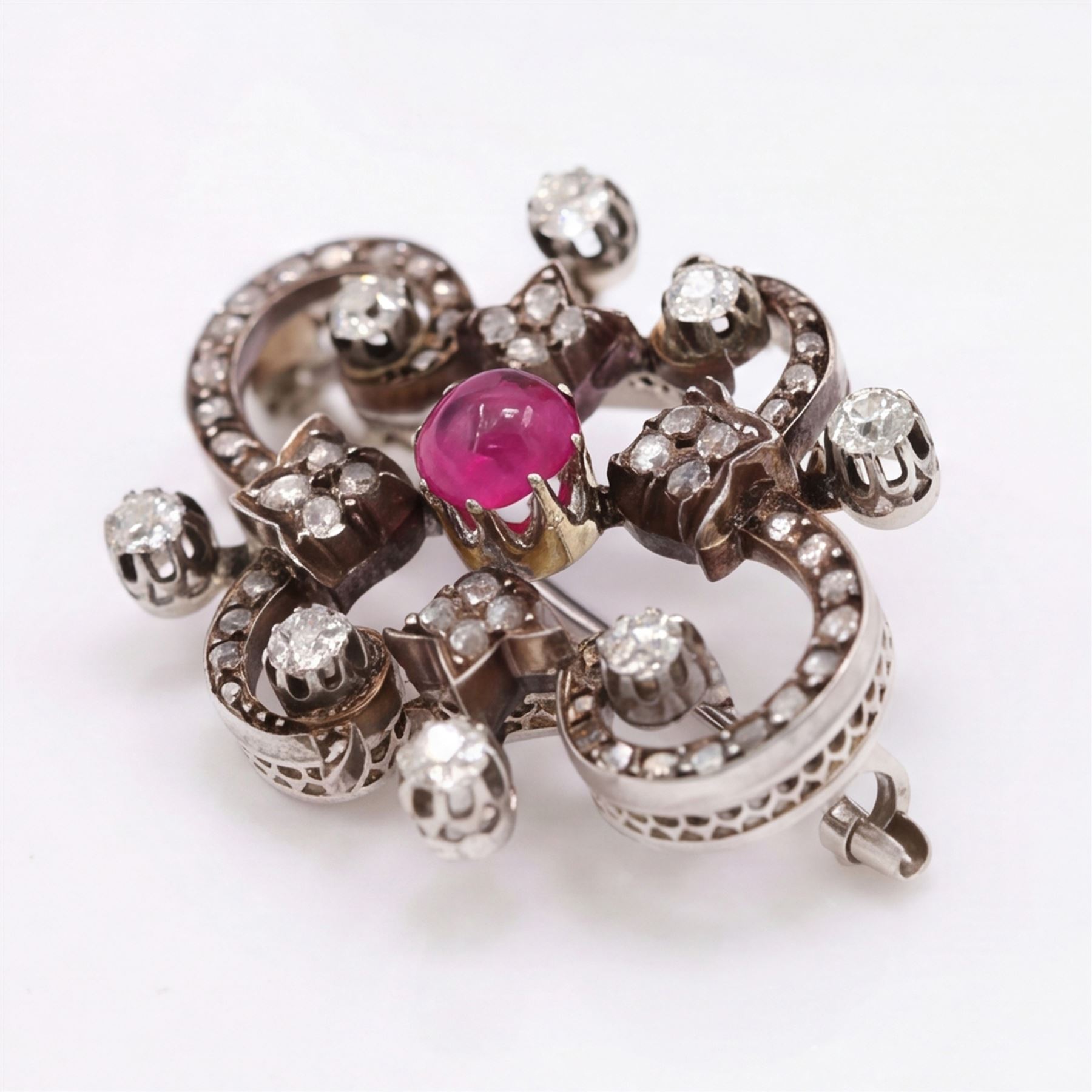 19th century French 18ct white gold ruby and diamond brooch by Eugène Fontenay, centrally set with a single cabochon cut ruby of approx 1.85 carat, the foliate scroll border set with eight old cut diamonds of approx 1.45 carat and rose cut diamonds, stamped with makers mark EF, eagles head and numbered 23960
