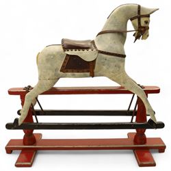 20th century carved and painted rocking horse, with original dappled paint finish, studded leather saddle and reins, on later red and black swing frame