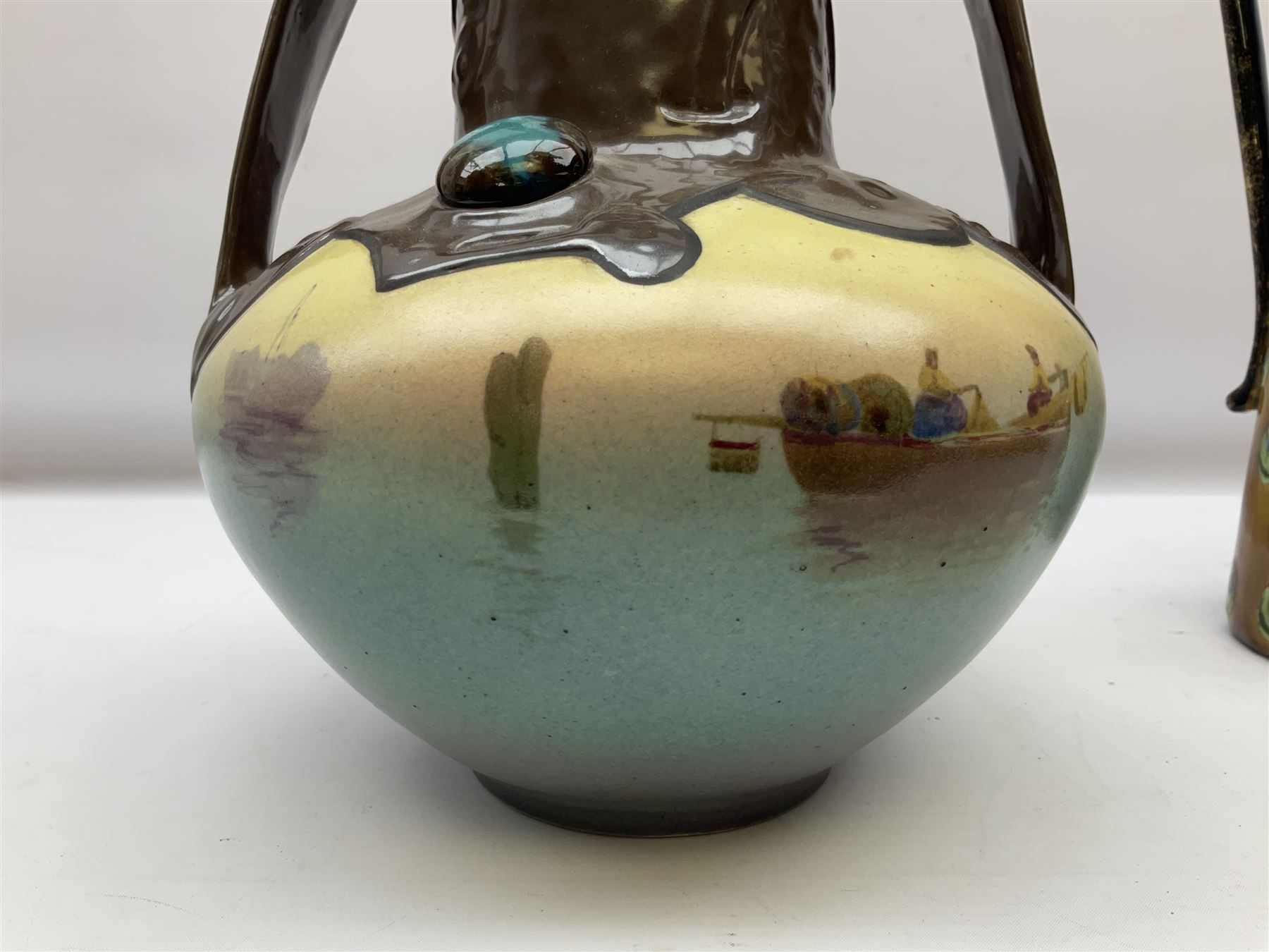 T. Forester Phoenix ware ewer of tapering form decorated with peacock and Bretby twin handled vase decorated with figures fishing in a boat sea scene