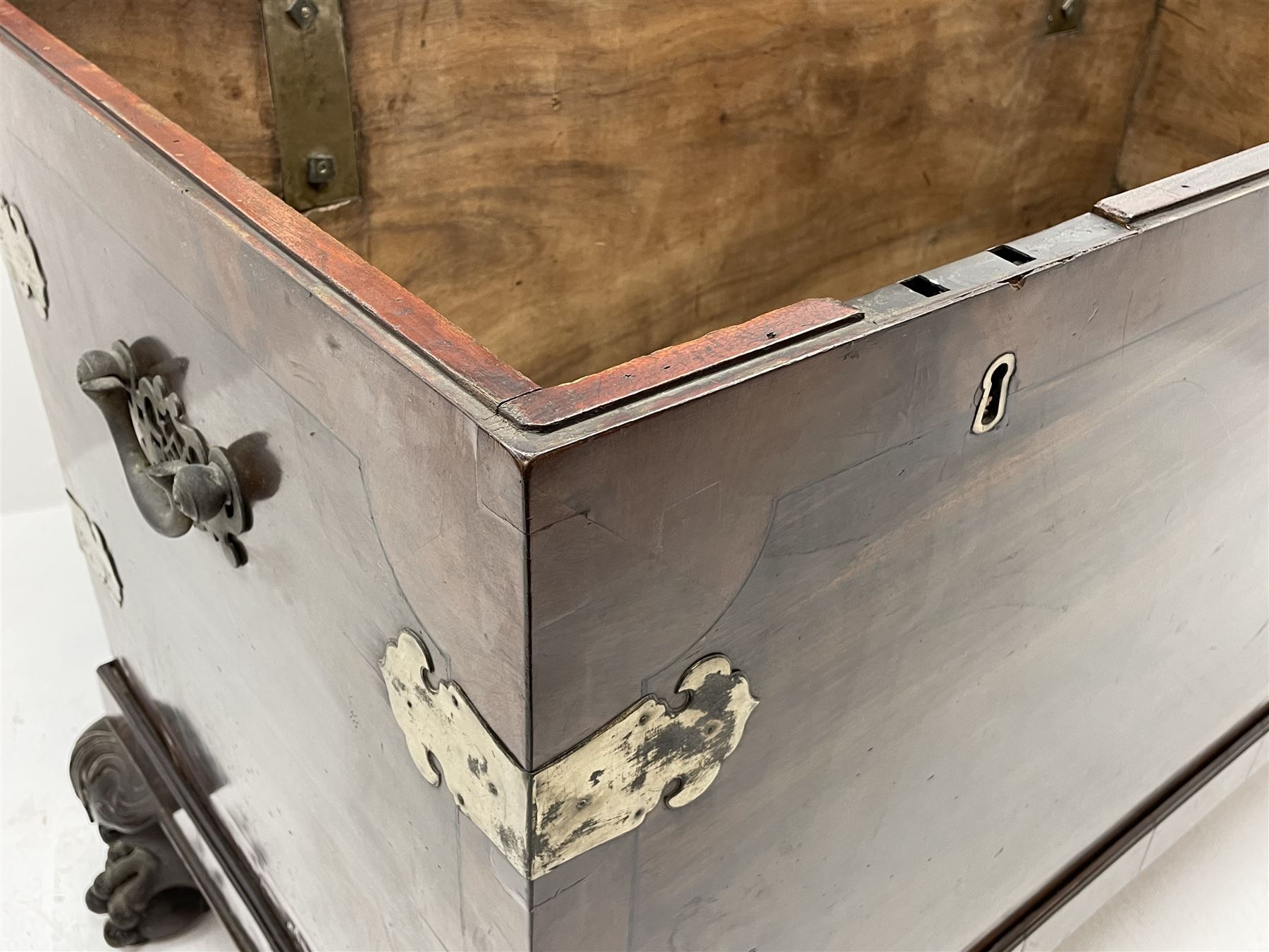 19th century camphor wood and mahogany silver chest, the hinged banded top with circular brass mounts which secure the interior strap hinges, fretwork metal strapping to the corners, on stand with plain frieze and acanthus carved cabriole ball and claw feet