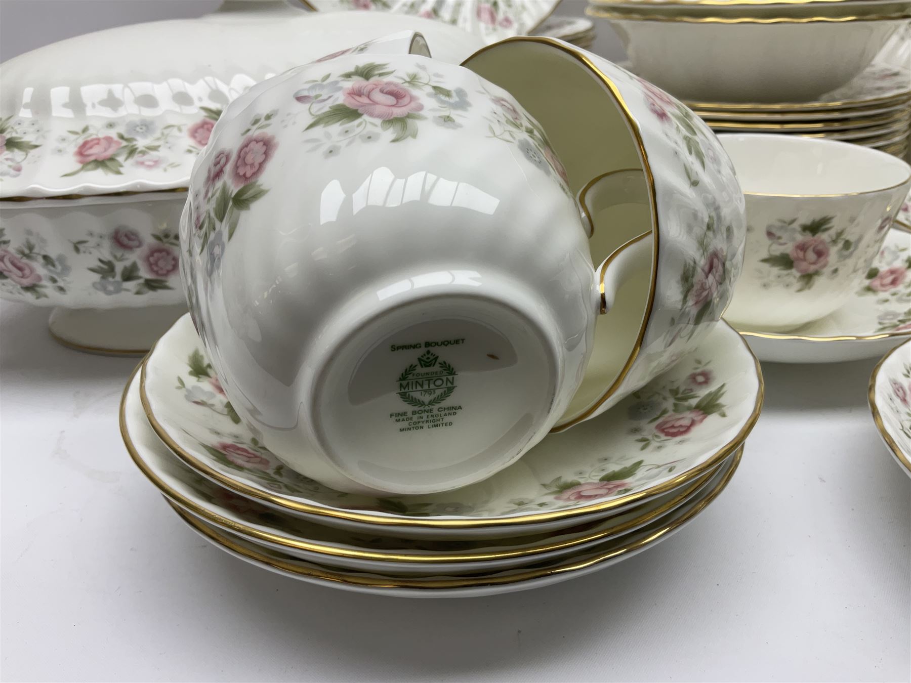 Minton Spring Bouquet pattern dinner and tea service, comprising dinner plates, twin handled tureens with covers, meat platter, teapot, milk jug, sugar bowl with cover, tea cups and saucers, bowls, cake plate, side plates, dessert plates, etc all with printed mark beneath (82)