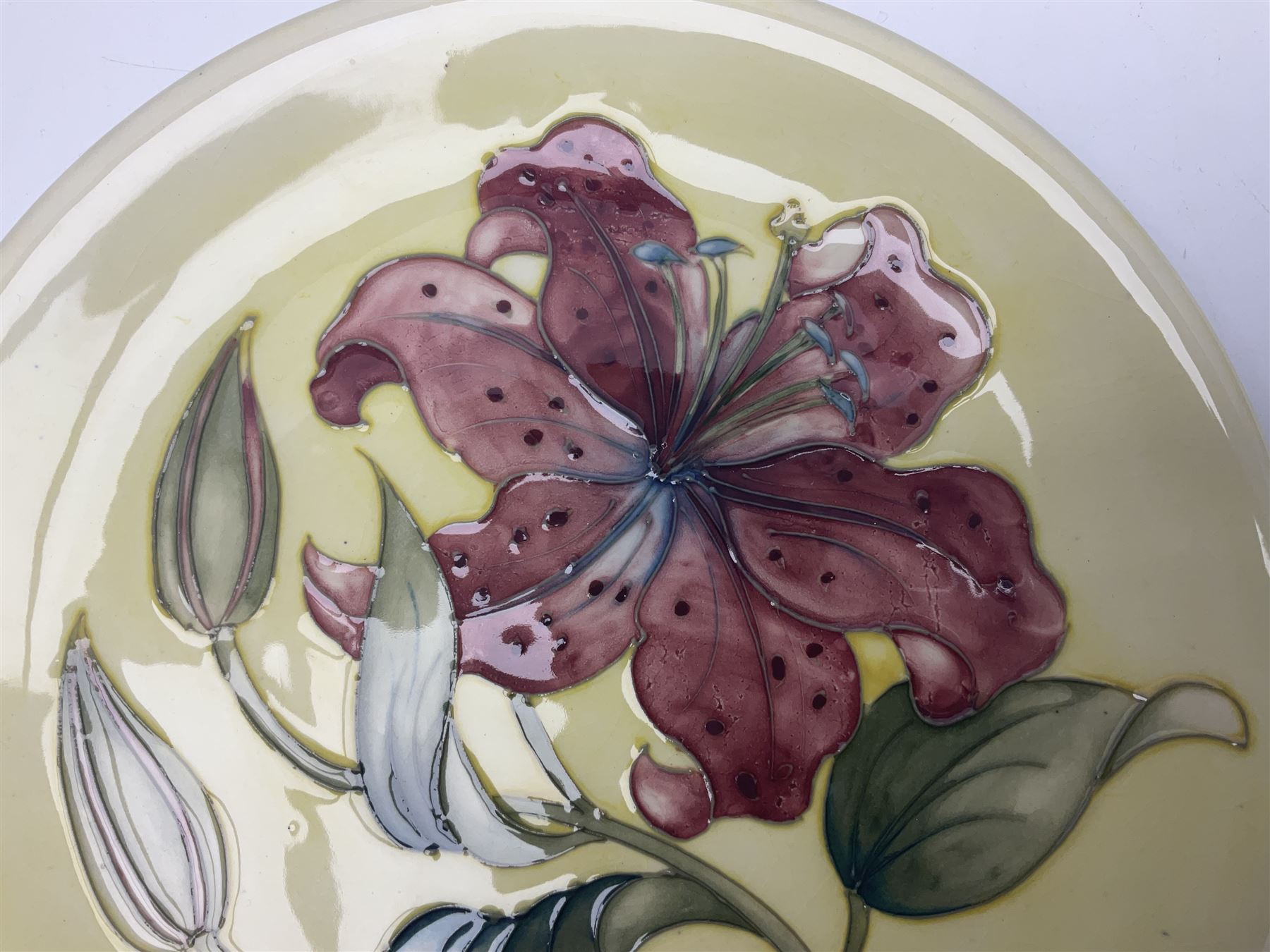 Moorcroft Tiger Lily pattern plate on a yellow ground, with painted and impressed mark beneath, D26cm