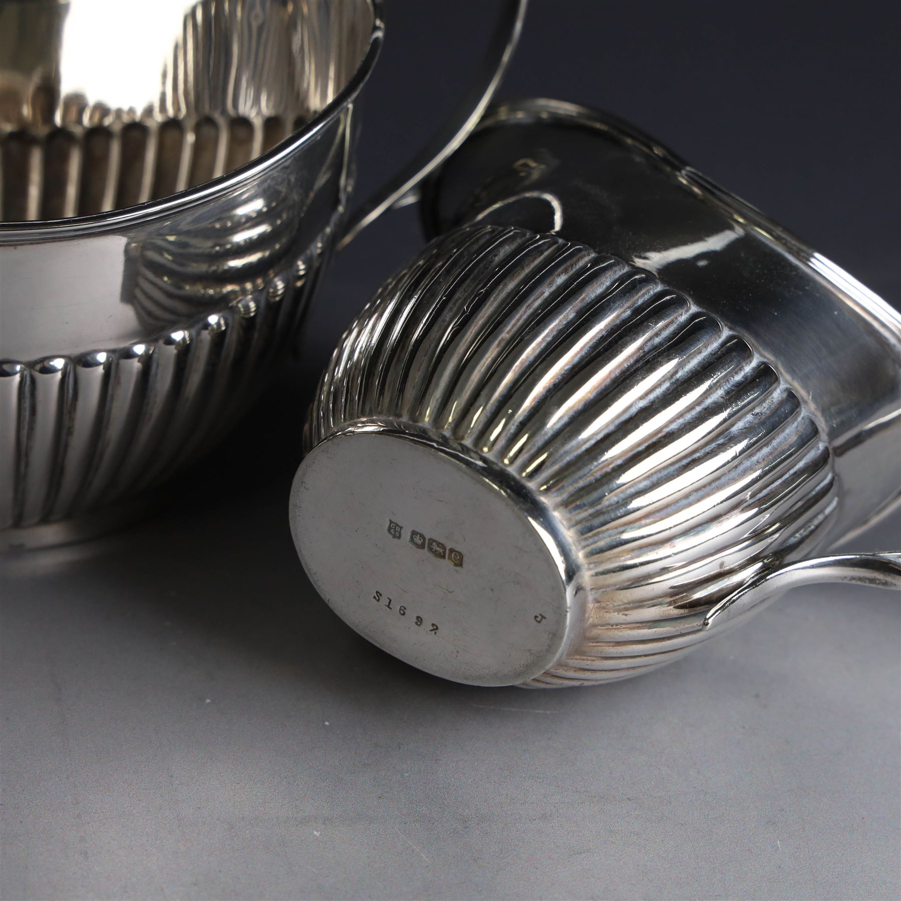 1920s silver three piece tea service, comprising teapot, twin handled open sucrier and milk jug, each of oval part fluted form, the teapot with Bakelite type handle and finial, hallmarked Cooper Brothers & Sons Ltd, Sheffield 1922