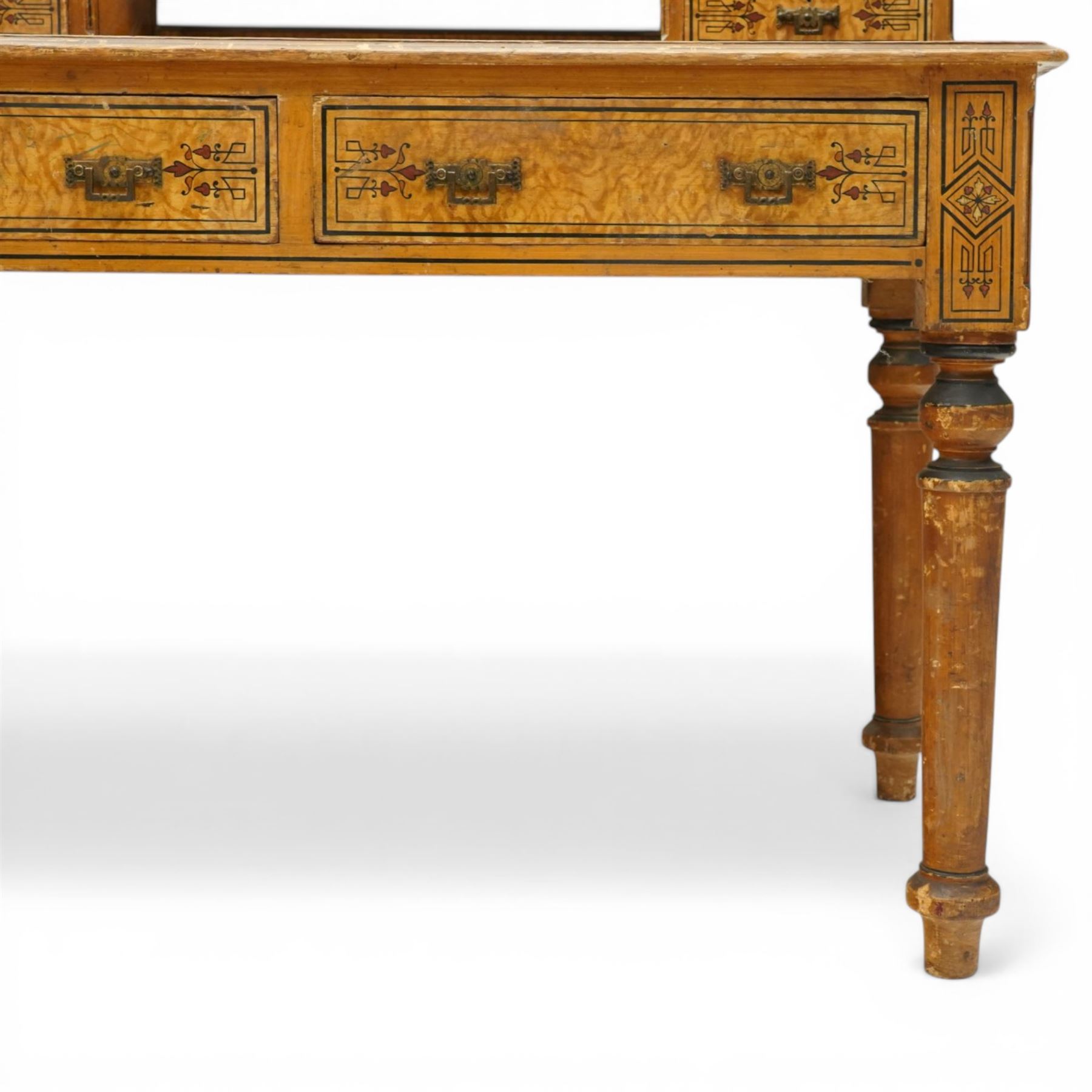 Late Victorian Aesthetic Movement scumbled and painted pine dressing table, arched swing mirror over four small trinket drawers, decorated with painted ebonised stringing and Aesthetic Movement motifs, rectangular top fitted with two drawers, on turned supports