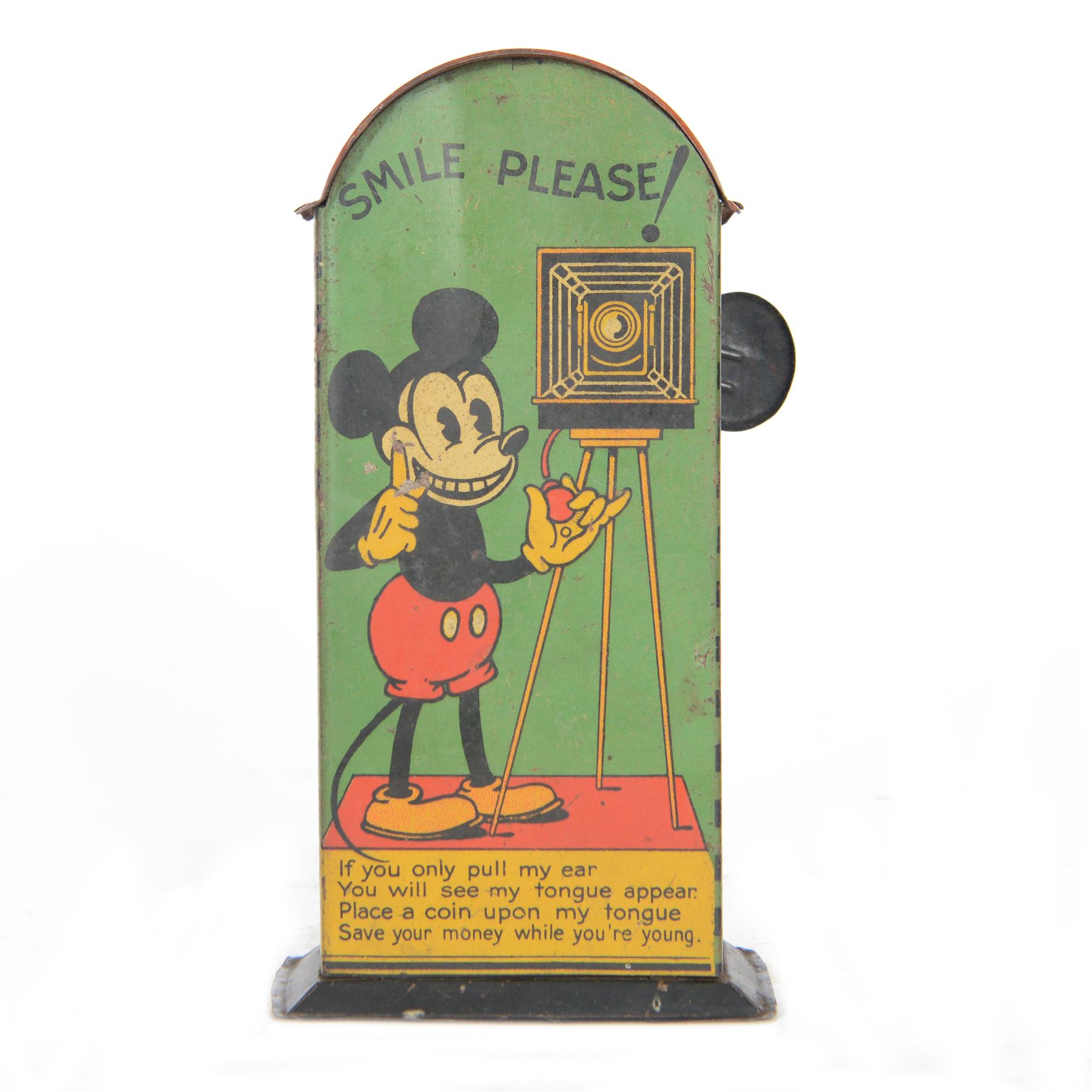 1930s Saalheimer & Strauss Mickey Mouse 'Smile Please' mechanical tin plate money box, depicting Mickey Mouse posing with folded hands to the front and verso as a photographer, above the motto 'If you only pull my ear you will see my tongue appear. Place a coin upon my tongue save your money while you're young', marked to one side 'By exclusive arrangement with Ideal Films Ltd. All rights reserved. Registered No 508041', with key, H17cm

