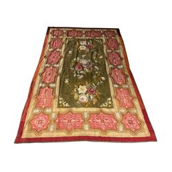 Needlework rug, green ground field decorated with flowers, the border decorated with a series of geometric panels with scroll and anthemion decoration, Greek key outer border 