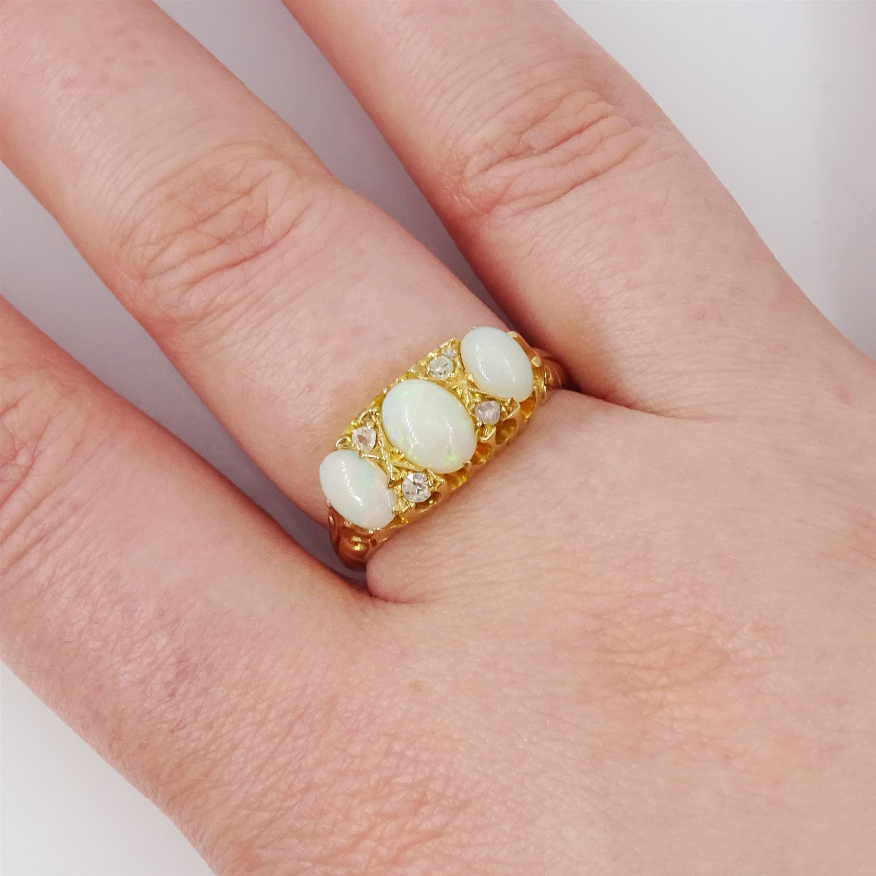 Early 20th century 18ct gold opal and diamond ring, three graduated oval cut opals, spaced by four accent diamonds
