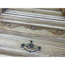 Late 19th century ash combination wardrobe, projecting cornice over foliage carved frieze, the left-hand upright enclosed by mirror glazed door, the right-hand side fitted with double panelled cupboard over two short and three long drawers, the upper panels carved with curled leaves and central scroll cartouche, on bracketed plinth 