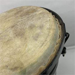 Native conga drum, with green painted coopered wooden body, pig skin head and metal tensioners; bears printed paper label 'Carakaitu Tumba' H66.5cm
