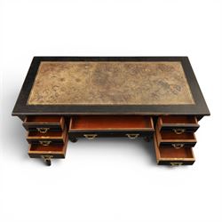 Victorian Aesthetic Movement ebonised writing desk, rectangular top with inset tooled leather, central frieze drawer with pierced spandrels, flanked by two banks of three drawers, brass swing handles, raised on turned supports 