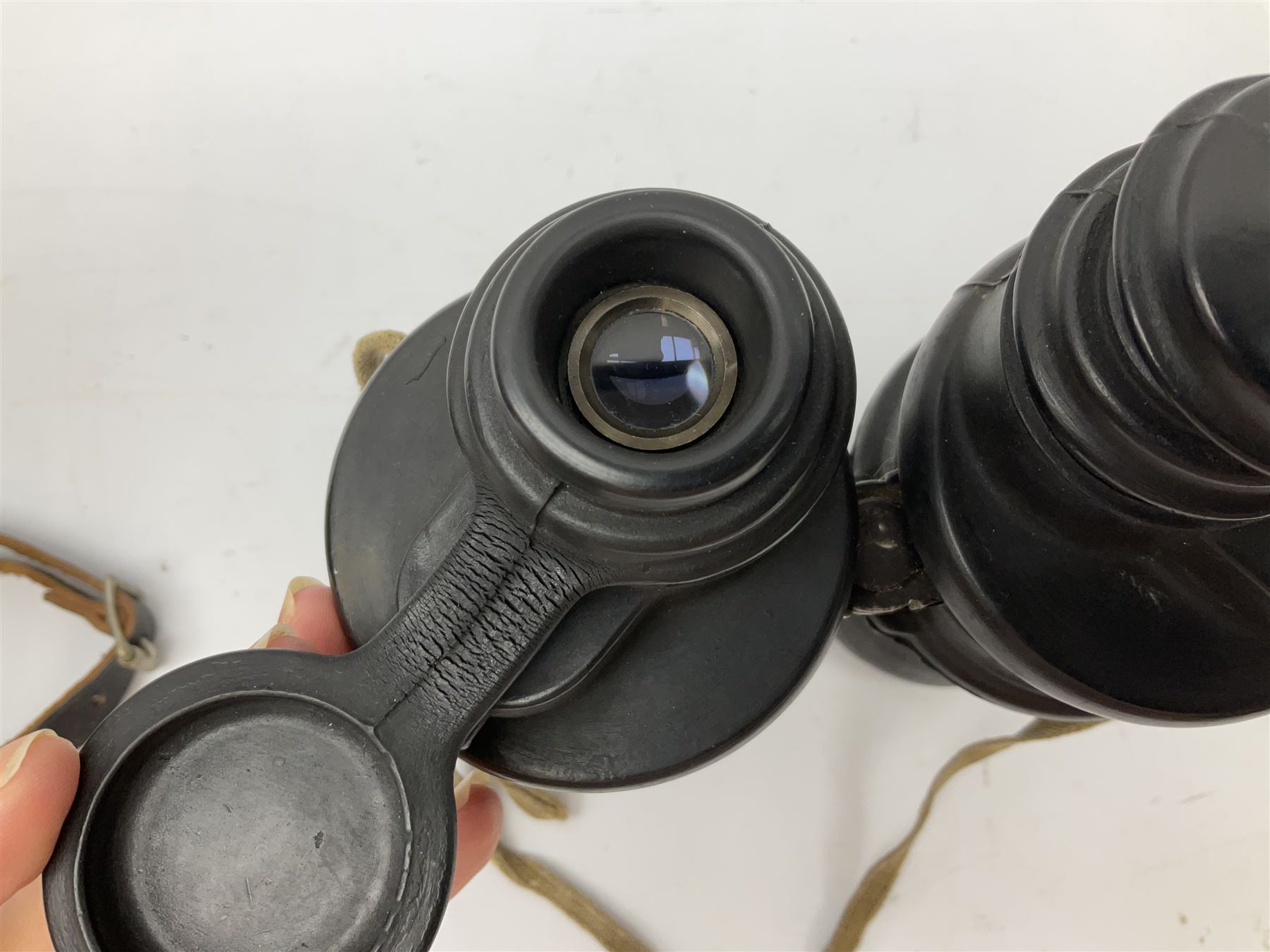 Pair of WWII German U-boat binoculars probably 7 x 50 by Leitz, with rubber eye piece protector covers and leather case stamped with Kriegsmarine mark to the lid and dated 1944, with leather strap.