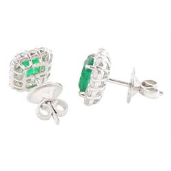 Pair of 18ct white gold emerald and diamond cluster earrings, each stud set with a single octagonal cut emerald, with round brilliant cut diamond surround, stamped, total emerald weight approx 1.30 carat, total diamond weight approx 0.70 carat