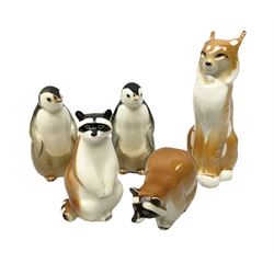 Collection of ceramic USSR animal figures, comprising lynx, two penguins and two raccoons, all with stamped marks beneath, tallest H21cm