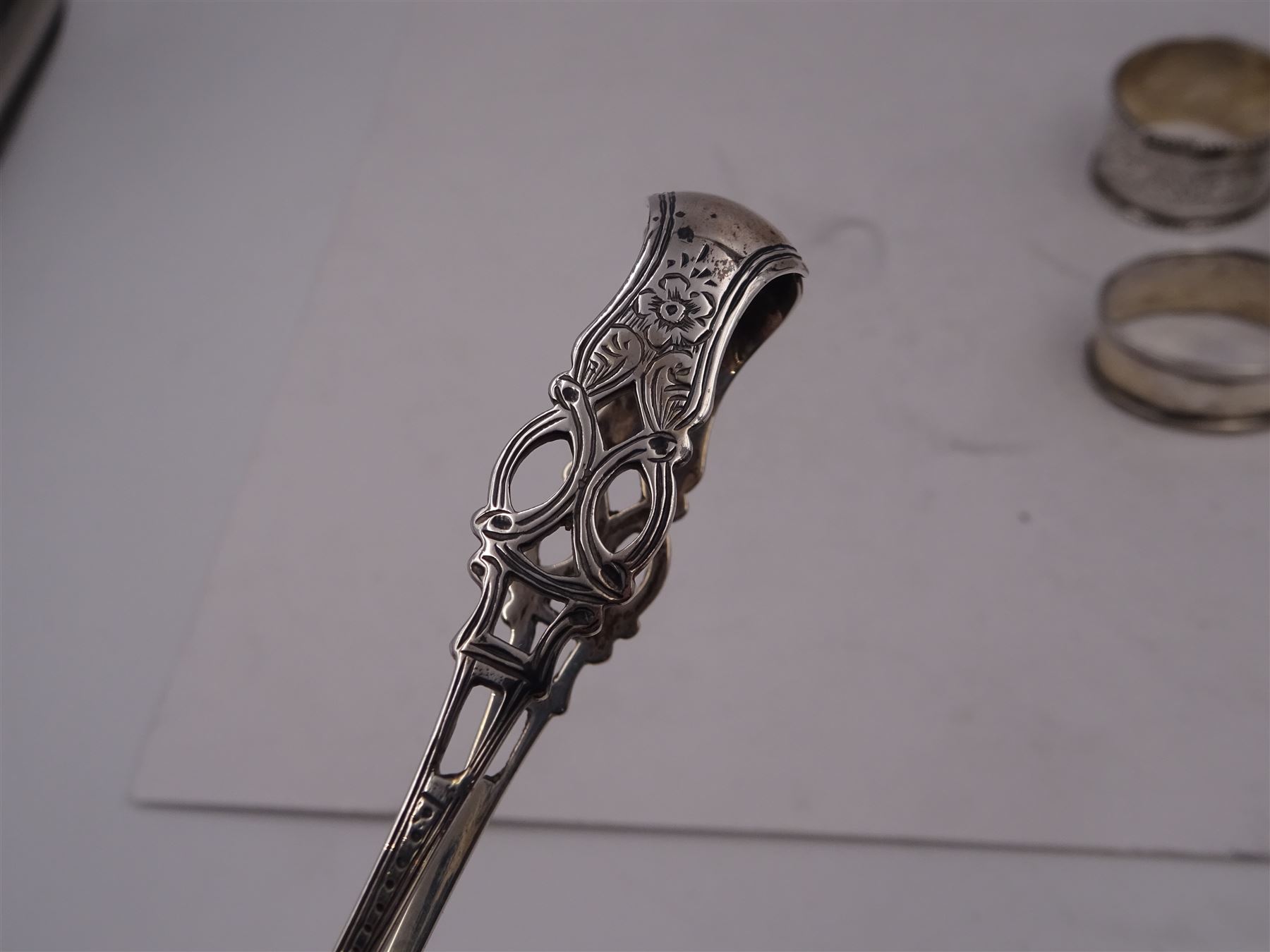 Pair of Victorian silver sugar tongs, with pierced decoration, hallmarked Hilliard & Thomason, Birmingham 1892, together with three hallmarked silver napkin rings