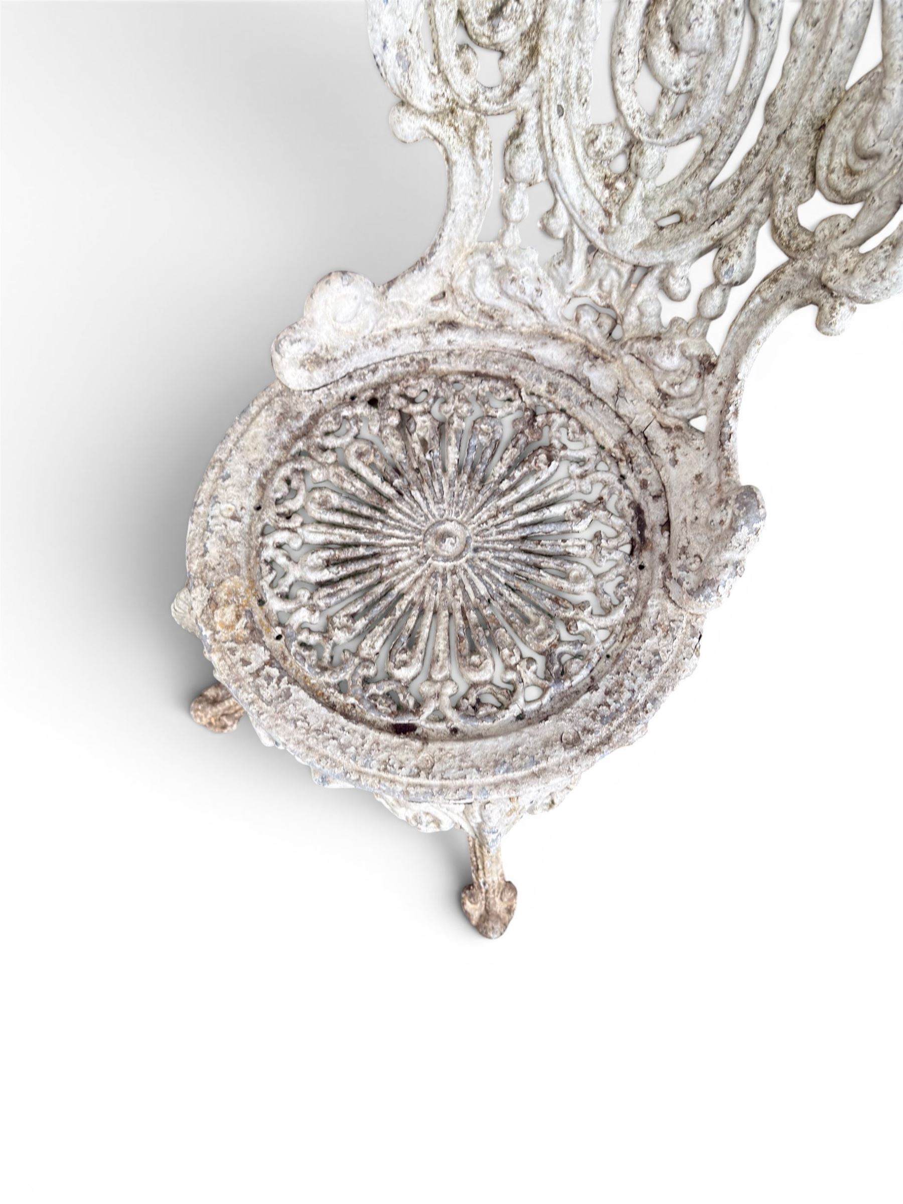 Pair of white painted cast metal garden chairs, ornate reclined backs, circular pierced seats on cabriole legs