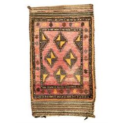 Antique Persian red ground saddle bag, decorated with all-over Boteh motifs, geometric patterned border (127cm x 68cm); Persian indigo ground saddle bag, decorated with two geometric ivory lozenges (113cm x 62cm); Persian red ground saddle bag decorated with lozenges and multi-band border (110cm x 65cm) 