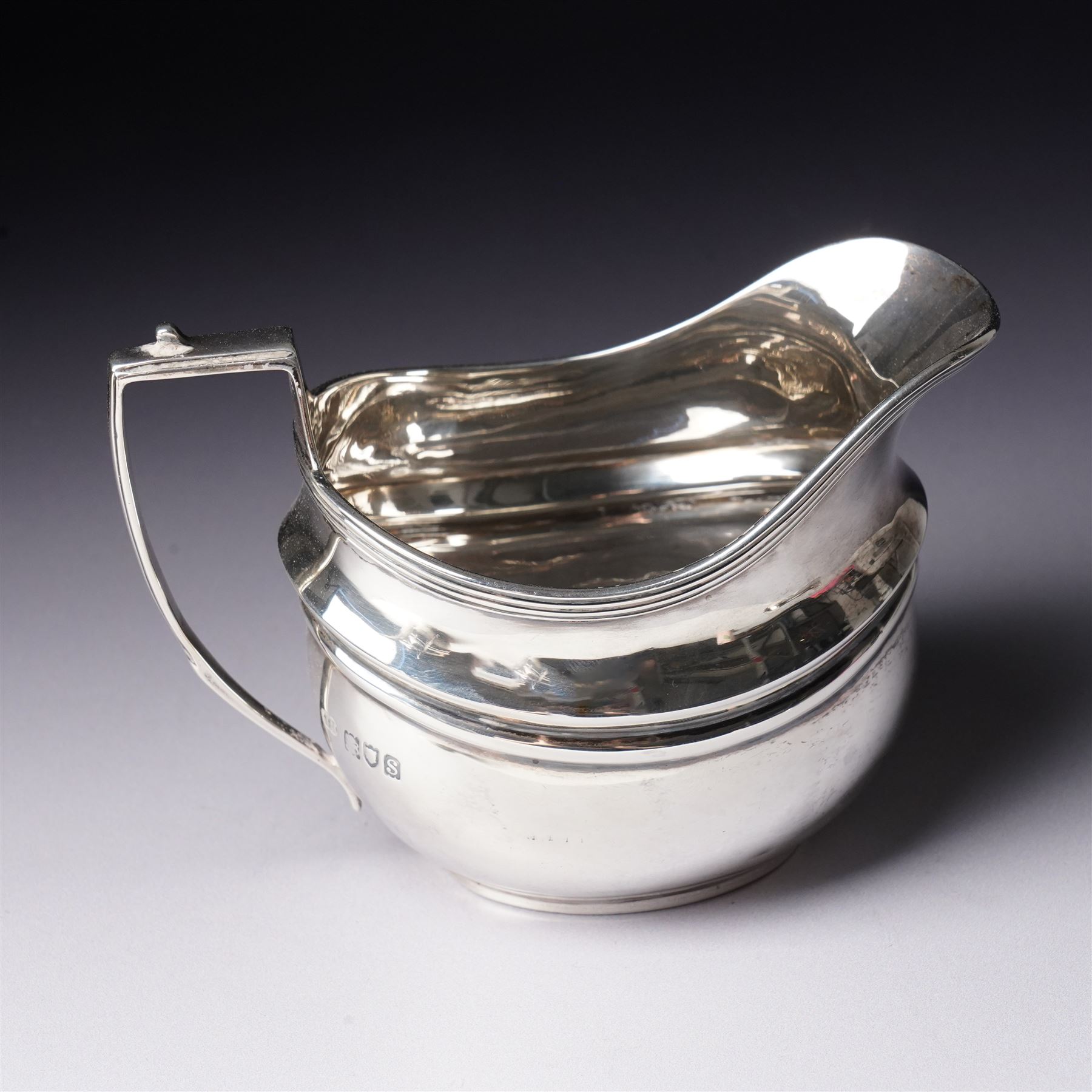Silver three piece tea set of oval form, the teapot with ebonised handle and lift London 1913 Maker John Hunt and a pair of Victorian silver sugar tongs
