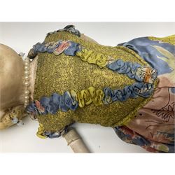 Victorian large wax over composition Pumpkin head doll, with inset dark glass eyes, moulded blonde hair in curls, stuffed body with carved and painted wooden limbs, grey painted boots, floral satin dress with netting underclothes H61cm