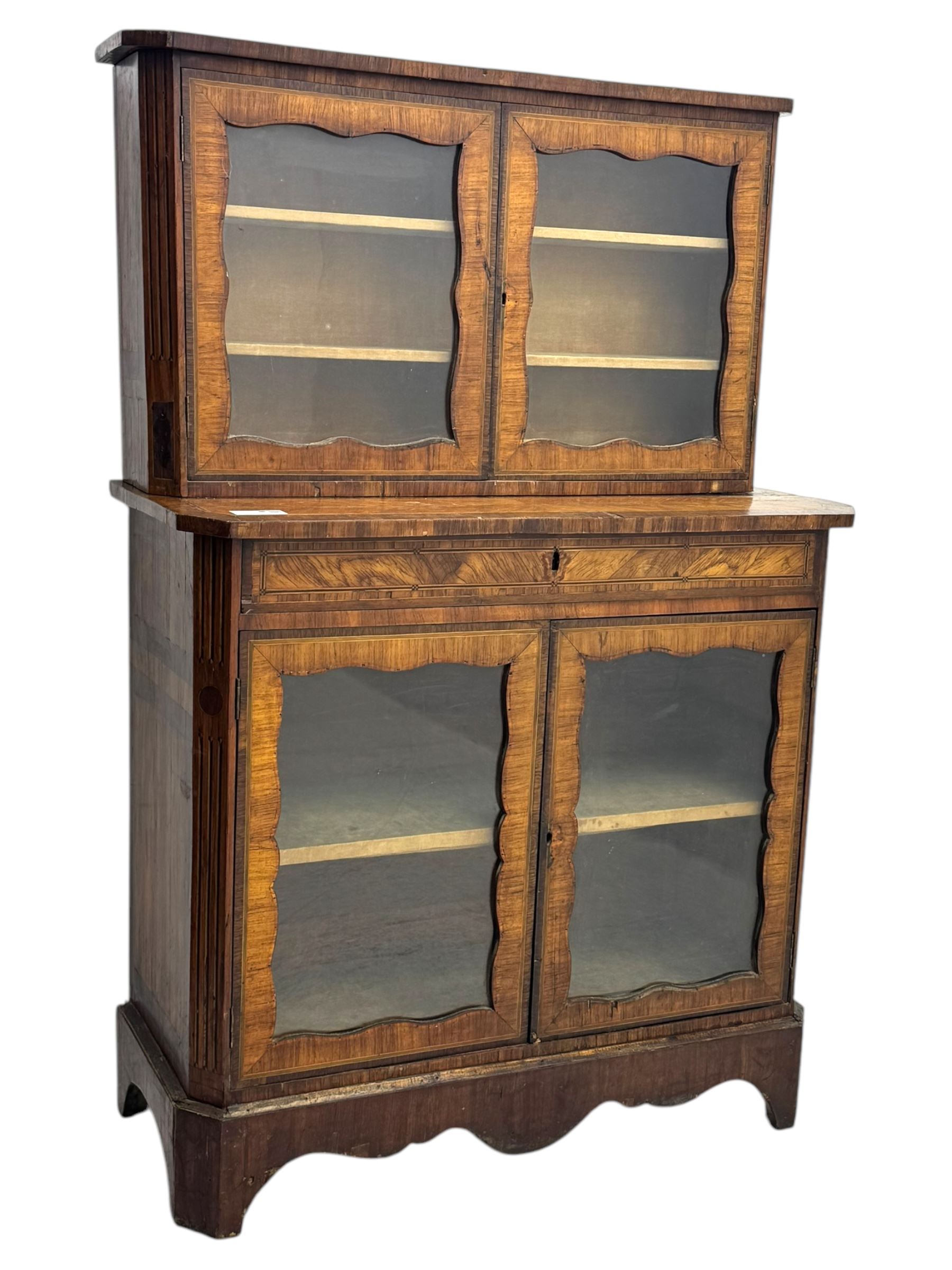Late 19th century continental display cabinet, the upper section is glazed with twin doors with two upholster shelves, over a lower section with single draw above two glazed cupboard doors on shaped bracket feet