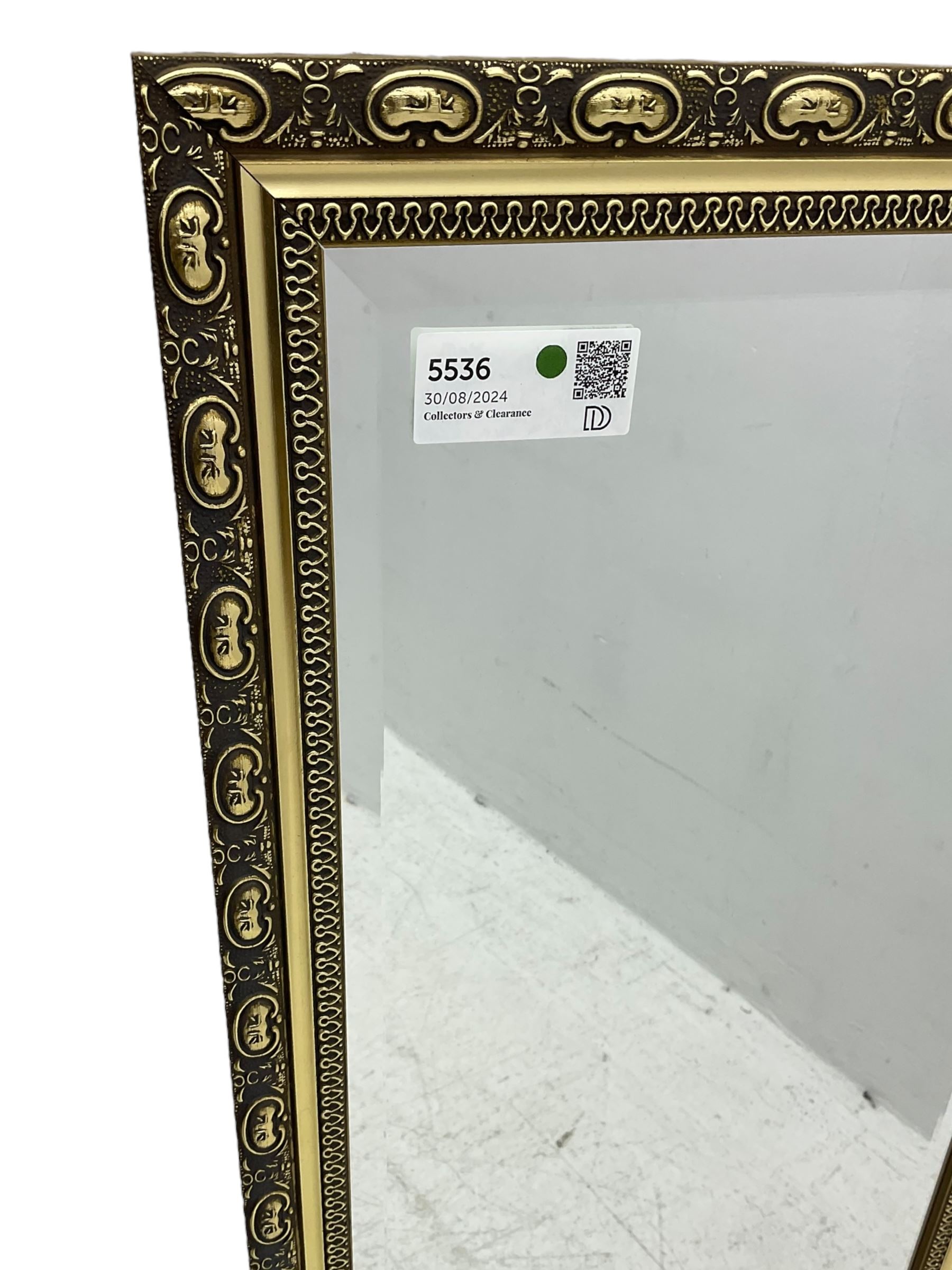 Gilt framed wall mirror, rectangular bevelled mirror plate enclosed by gilt-edged border with continuous wave pattern, outer border with oval medallions and foliate designs