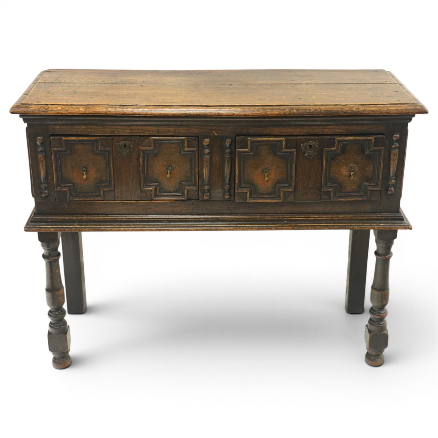 Georgian oak dresser base, plank top above an arrangement of two fielded panel drawers with moulded geometric fronts, on turned front supports and block rear legs