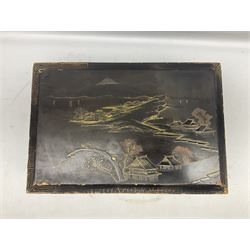 Early 20th century Japanese lacquered writing box, the hinged lid decorated with village scene with Mount Fuji in the distance opening to reveal compartmented interior with folding writing slope, with twin handles, W47cm H20cm D32cm