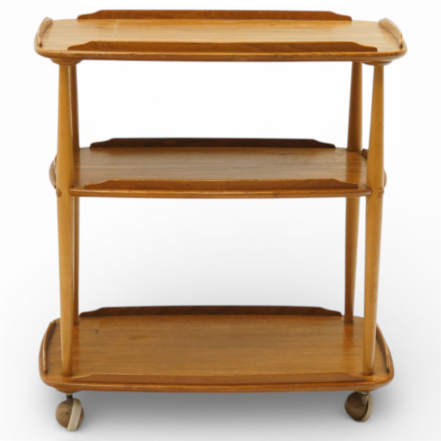 Ercol - elm tea trolley, Model 458. Rectangular three-tier form with shaped gallery edges, supported on turned upright supports, raised on castors