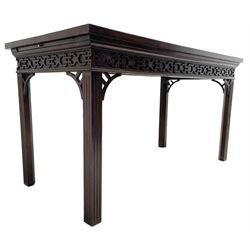 In the manner of Thomas Chippendale - early 19th century mahogany serving table, rectangular crossbanded top with boxwood stringing, the frieze with upper moulding over applied geometric fretwork, the left-hand side fitted with slide, on fluted square supports with inner chamfer 