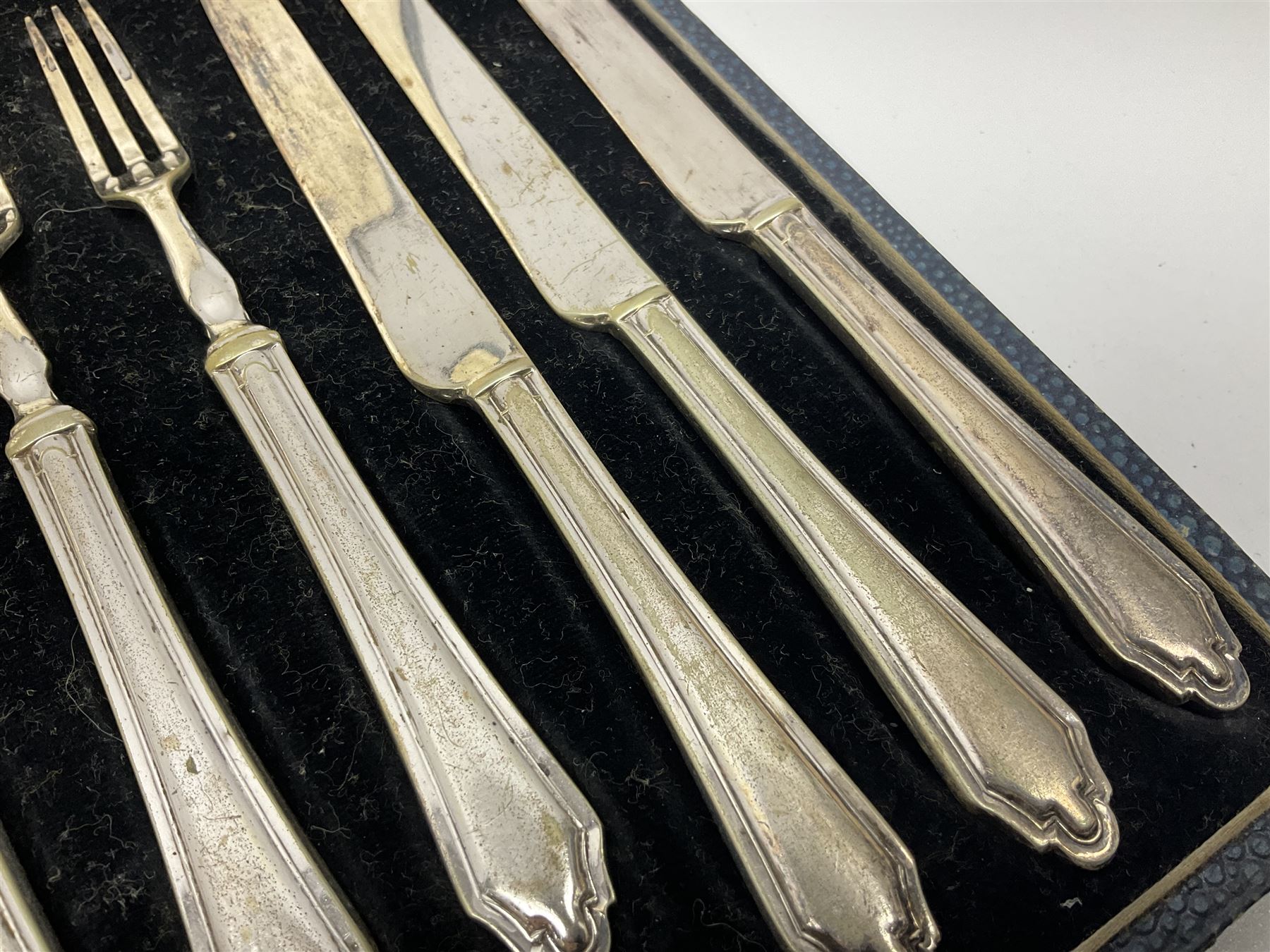 Set of six stag horn handled knives by Cooper Brothers and Sons, together with a set of silver plated dessert knives and forks for six place settings, both within fitted cases