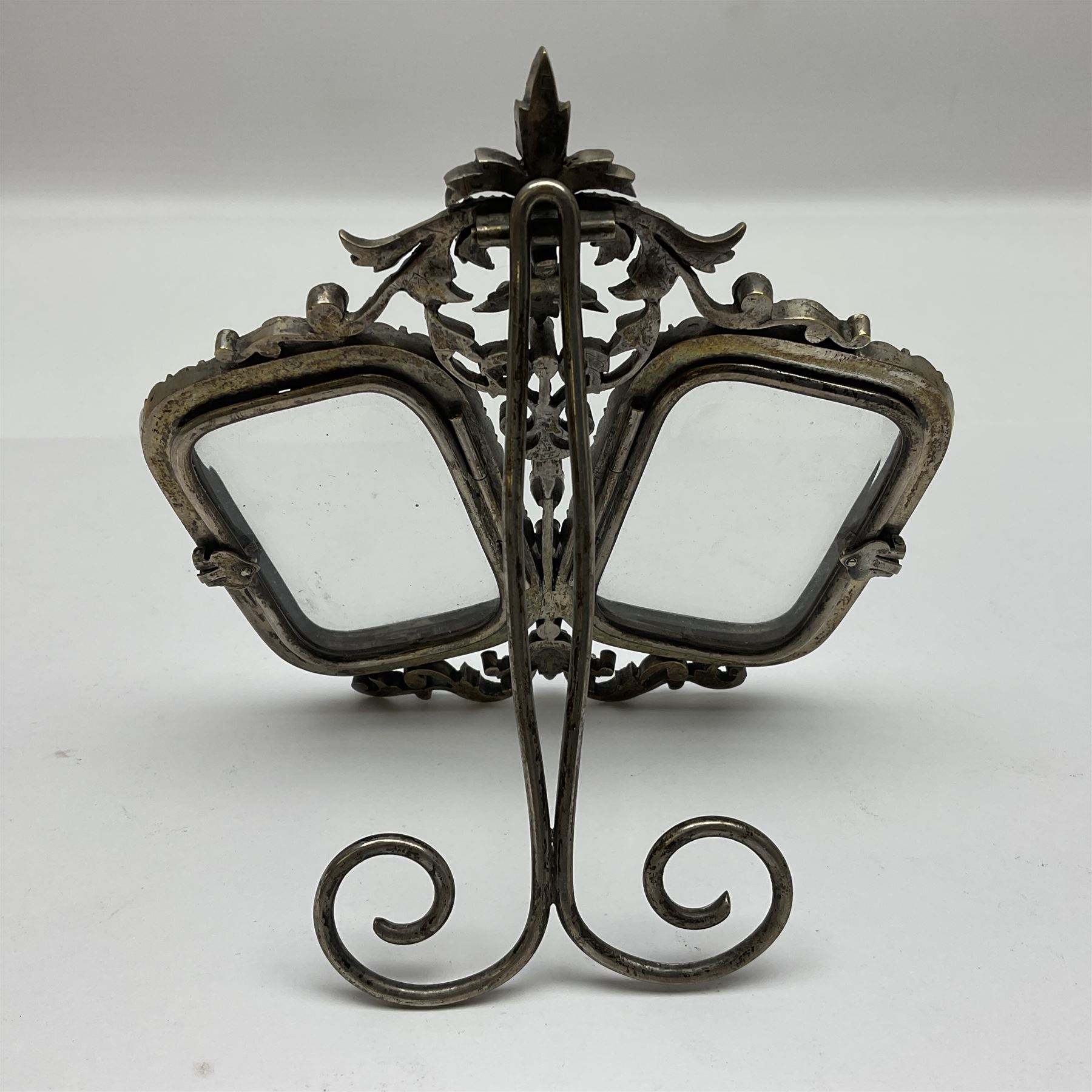 Early 19th century silver plated double photograph frame, each rounded rectangular aperture surrounded by a paste border, with ornate scroll feet and mantling also set with clear paste stones, with easel style support verso, H12cm