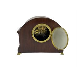 Mahogany cased eight-day mantle clock c1910 with an eight-day spring driven French movement striking the hours and half hours on a coiled gong, case with a break arch top and contrasting inlaid stringing to the front, with recessed brass pillars, plinth raised on bracket feet, enamel dial with Arabic numerals and spade hands, convex glass within a brass bezel. With Pendulum.

