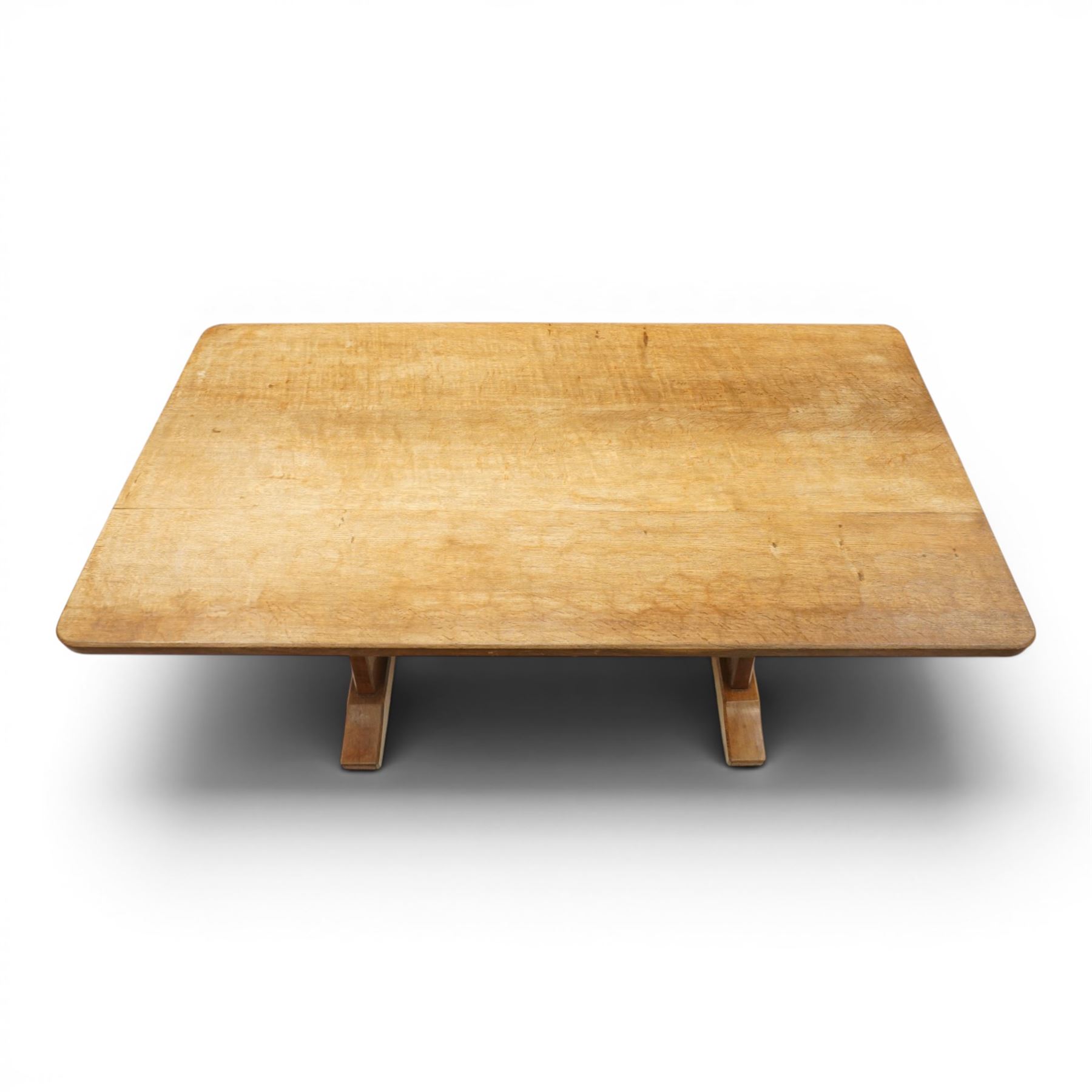 Acornman - 5' adzed oak dining table, rectangular top above a trestle base united by a stretcher with carved acorn signature, by the workshop of Alan Grainger of Brandsby