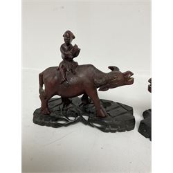 Pair of Chinese hardwood figures of farmers riding water buffalo, on stands, H19cm