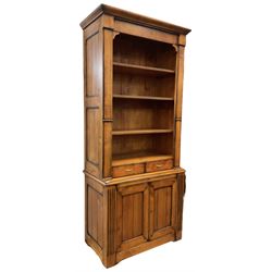 French cherry wood bookcase on cupboard, projecting moulded cornice over three shelves and two small drawers, the cupboard enclosed by two panelled doors flanked by fluted uprights