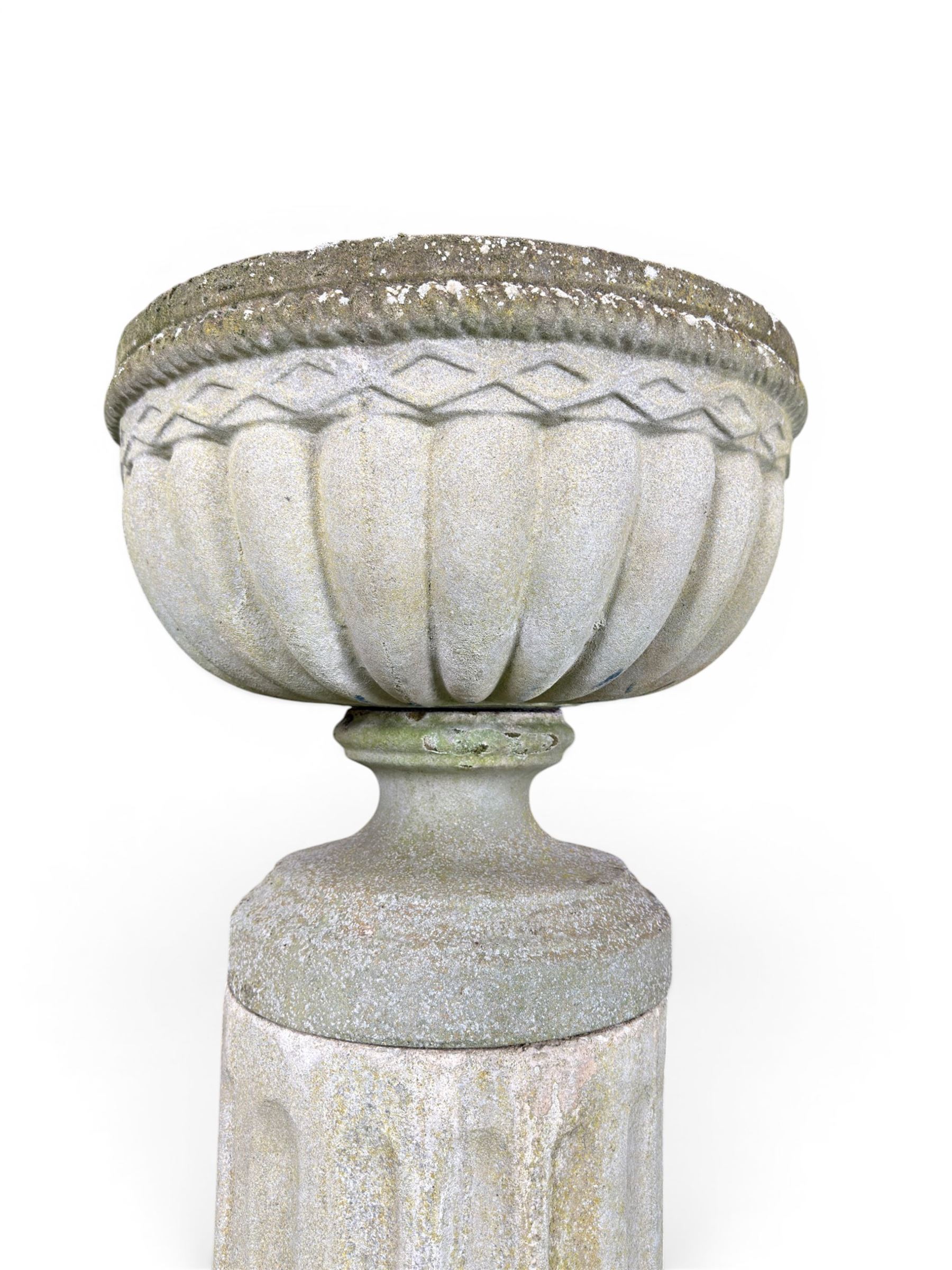 Four 20th century good quality weathered cast stone pedestal urns, circular lobed bowls with rope twist and lattice border, raised on squat base with fluted columns