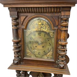 A compact early 20th century German wall clock c1910 in an oak case with applied carvings and decoration, with a brass dial with a chapter written in Arabic's, eight-day spring driven movement striking the hours and half hours on a gong, with visible pendulum beneath.

