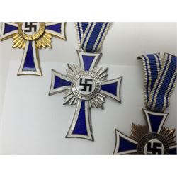 WWII set of three German Mother's Crosses, 1st Class in gilt, 2nd Class in silver and 3rd Class in bronze; all with ribbons (3)
