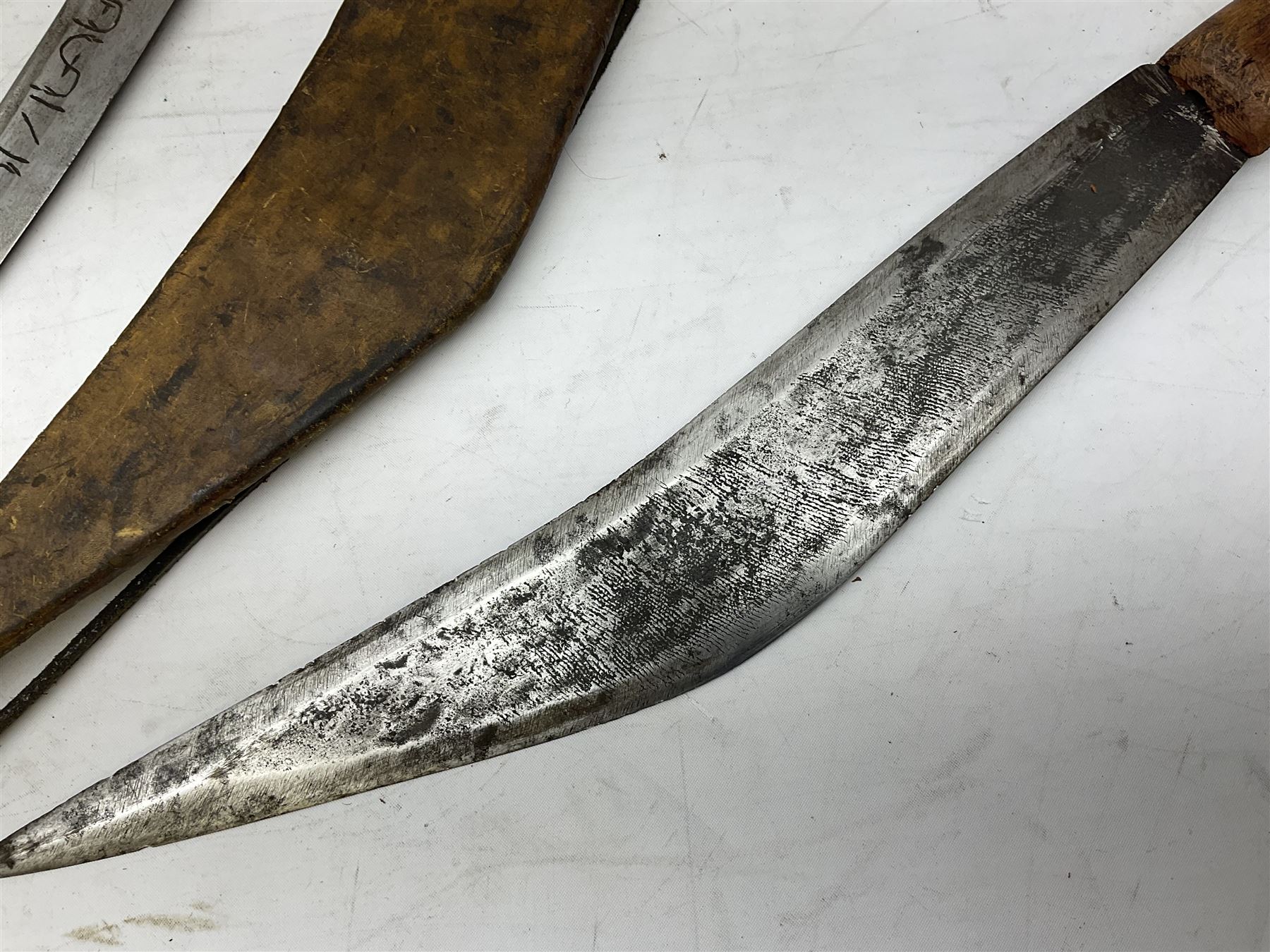 Near pair of African Moroccan Berber tribal Shula daggers each with engraved 39cm curving fullered steel blade, carved and inlaid horn grip and leather covered scabbard L57cm overall; kindjal style dagger with brass covered and jewelled grip and scabbard; another Eastern dagger with leather covered grip and scabbard; and a large Eastern knife with animal hide scabbard (5)