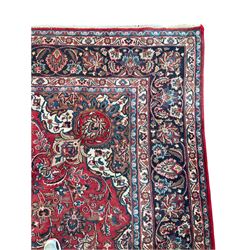 Large Persian Kashan carpet, red ground and decorated all-over with interlacing foliate and flower heads, central floral medallion, multi-band border with scrolling design 
